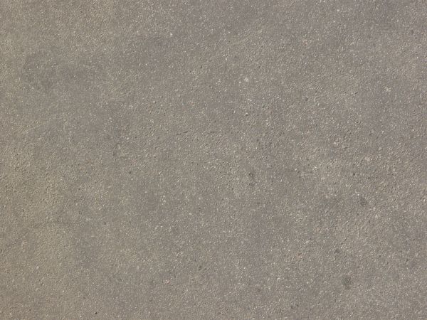 Consistent road of asphalt in light grey tone with slightly rough, flat surface.